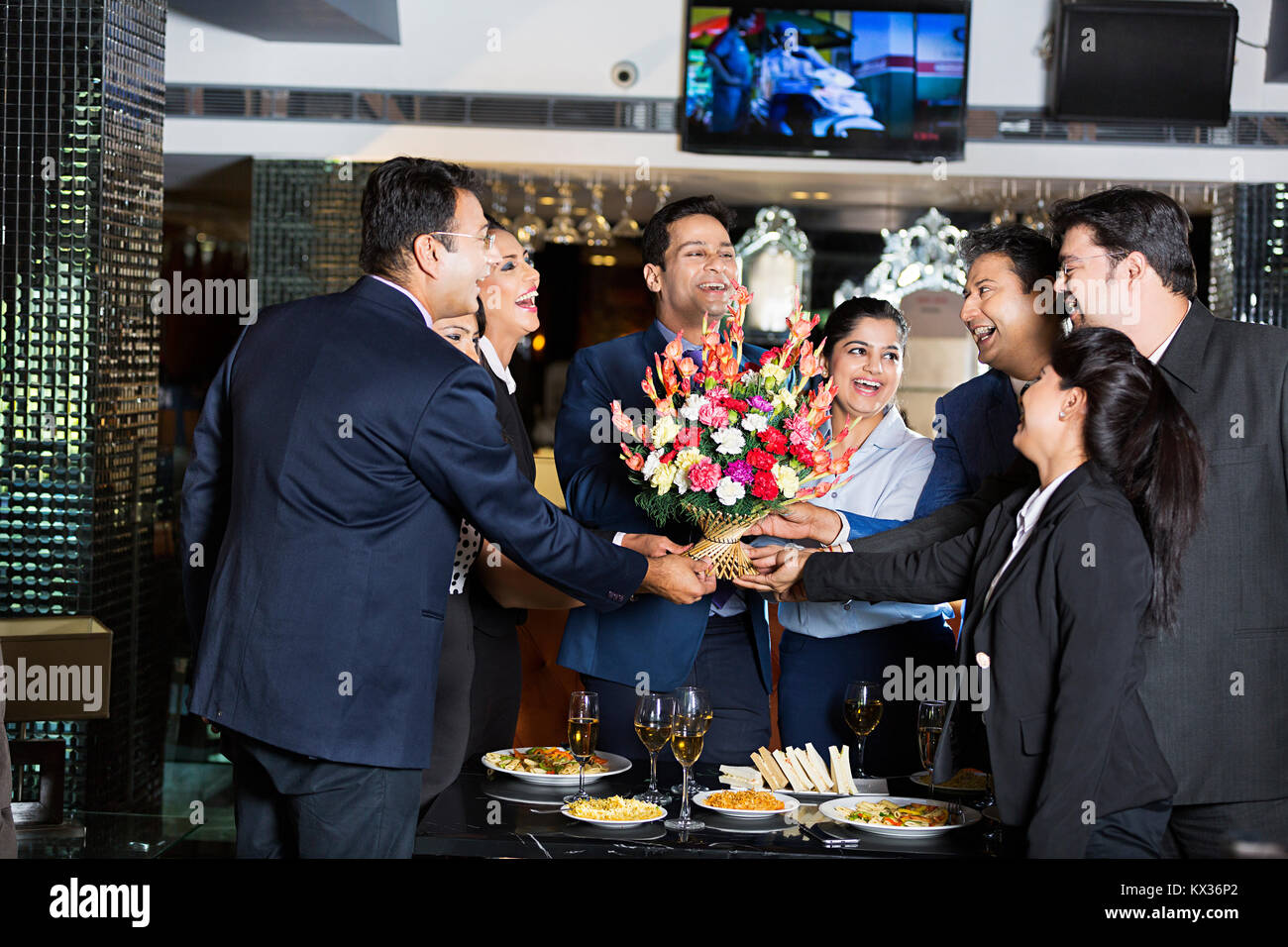 Gruppe Unternehmer und Unternehmerinnen Kollegen geben Blumenstrauß Chef Willkommen applaudieren Hotel Stockfoto