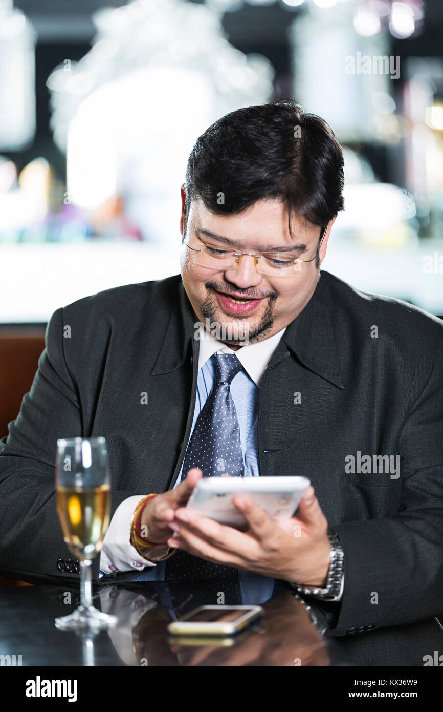 1 Business Mann sitzt im Restaurant lesen Text-Message auf Mobile-Phone Stockfoto