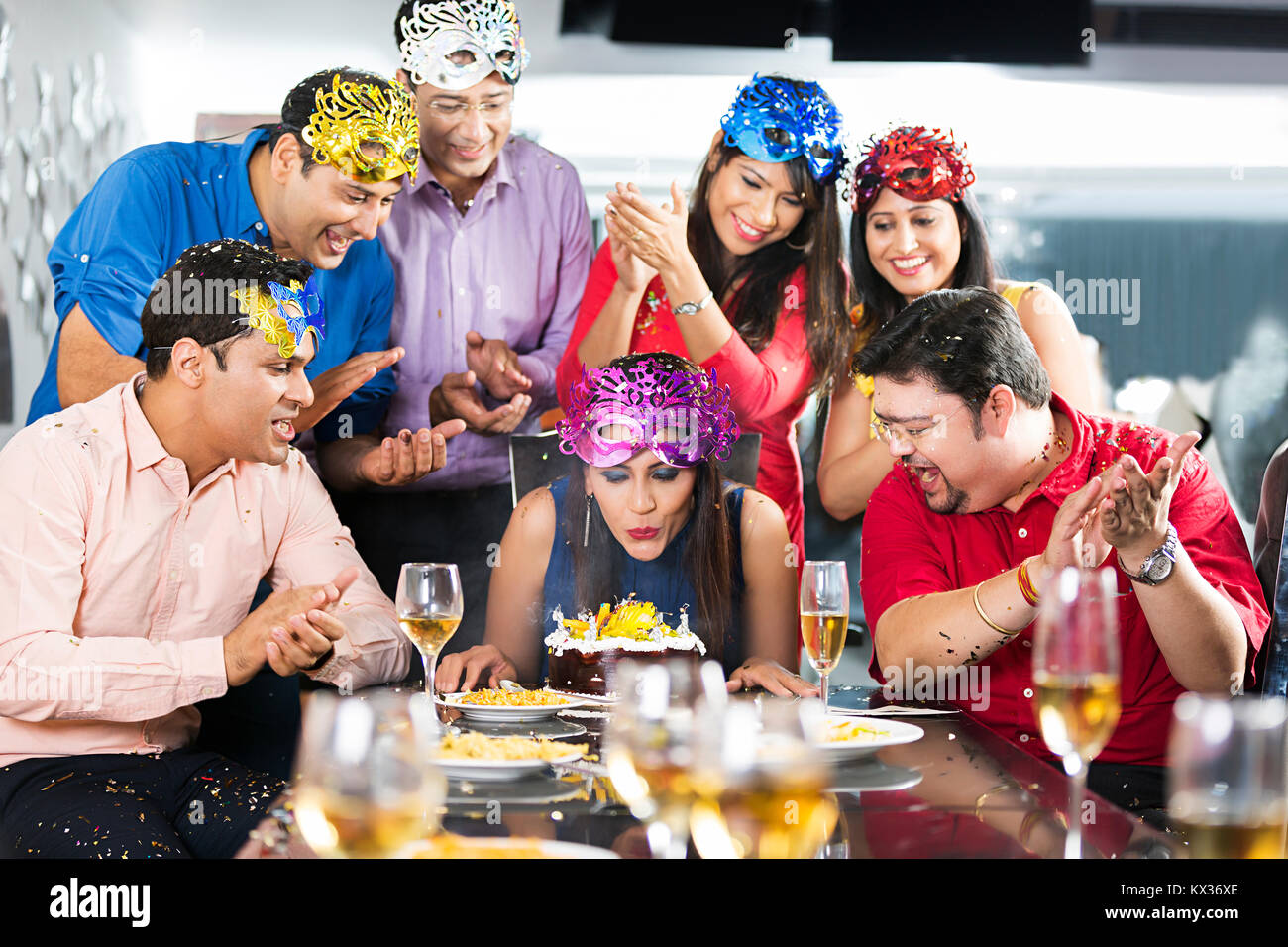 Erwachsene Frau ausblasen Kerzen auf dem Kuchen - Geburtstag feiert umgeben Stockfoto