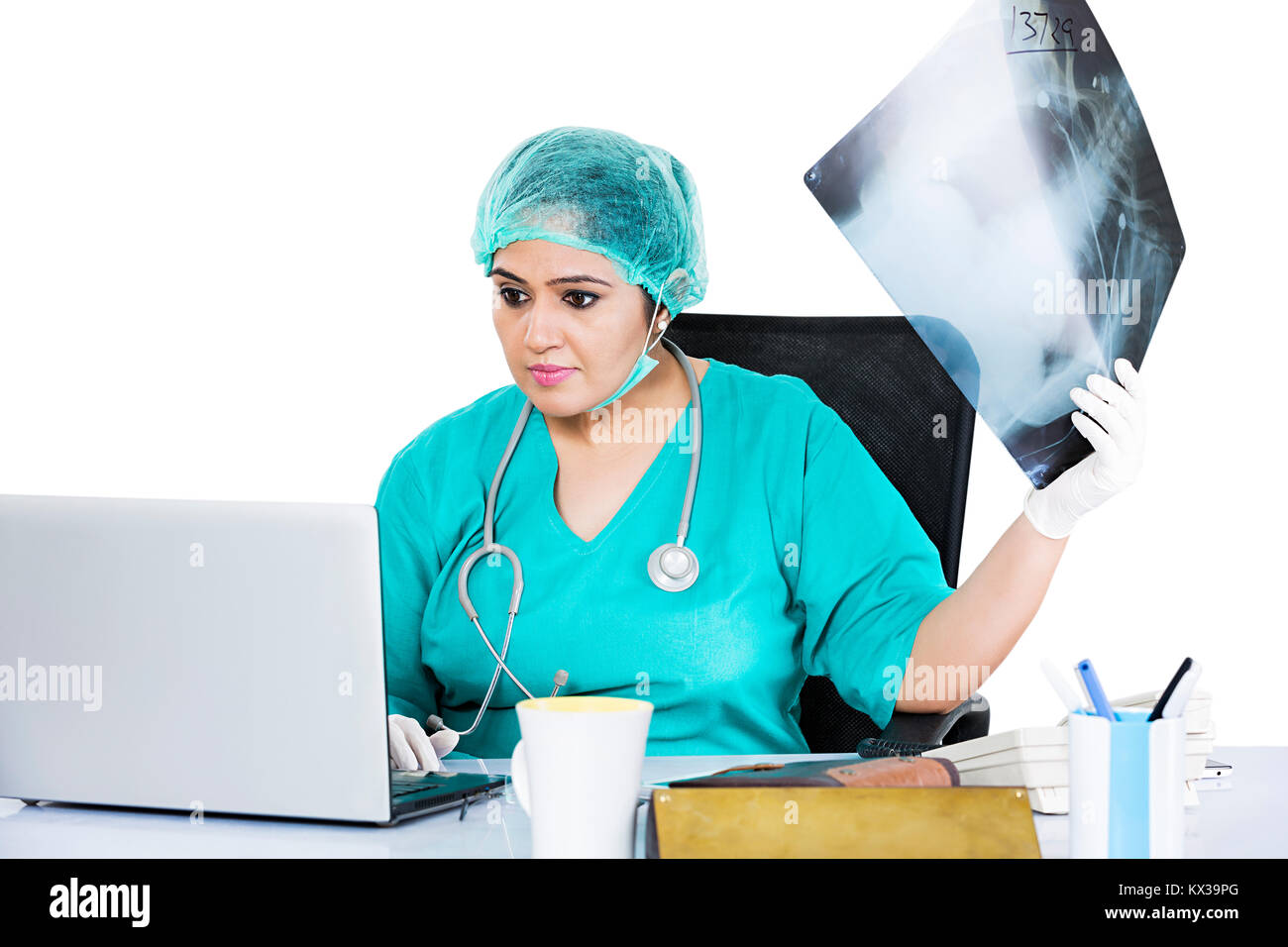 Indische Chirurg Arzt Frau prüfen X-ray Bericht mit Laptop Stockfoto