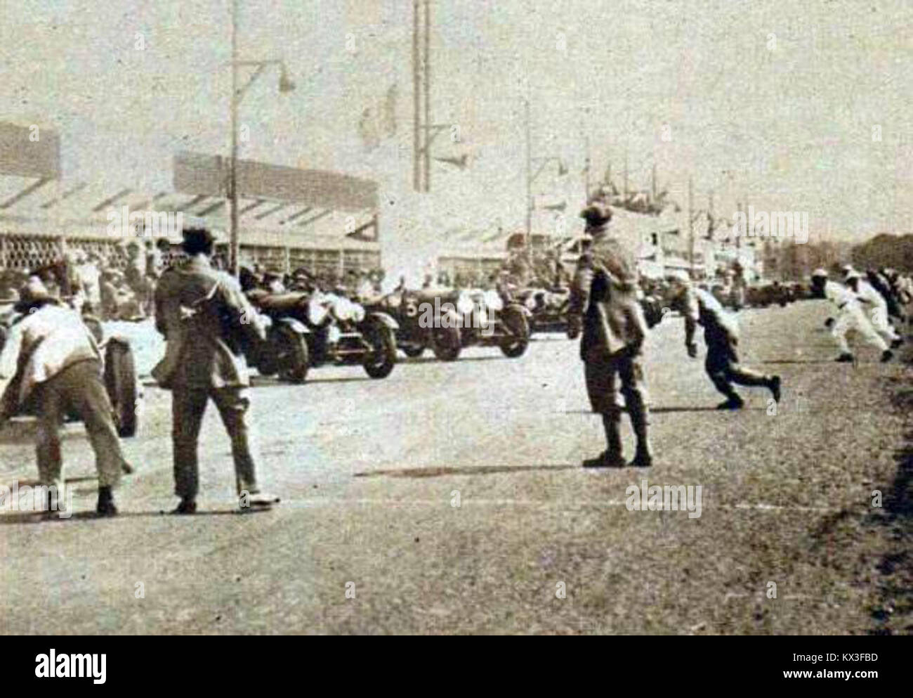 Ein historisches Bild fängt den Beginn der 24-Stunden-Tour von Le Mans 1928 ein und zeigt die Autos, Fahrer und Menschenmenge, was die Bedeutung dieses frühen Ausdauersportereignisses unterstreicht. Stockfoto