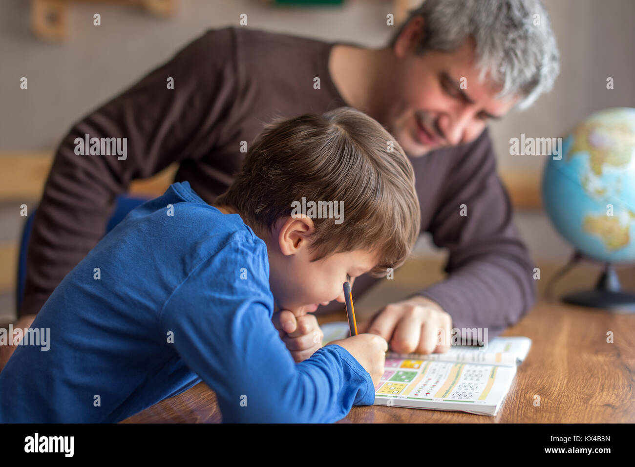 Jungen kleinen shoolboy Lösung Mathematik Hausaufgaben mit Vater, Zusammenarbeit in der Familie, Elternschaft Stockfoto