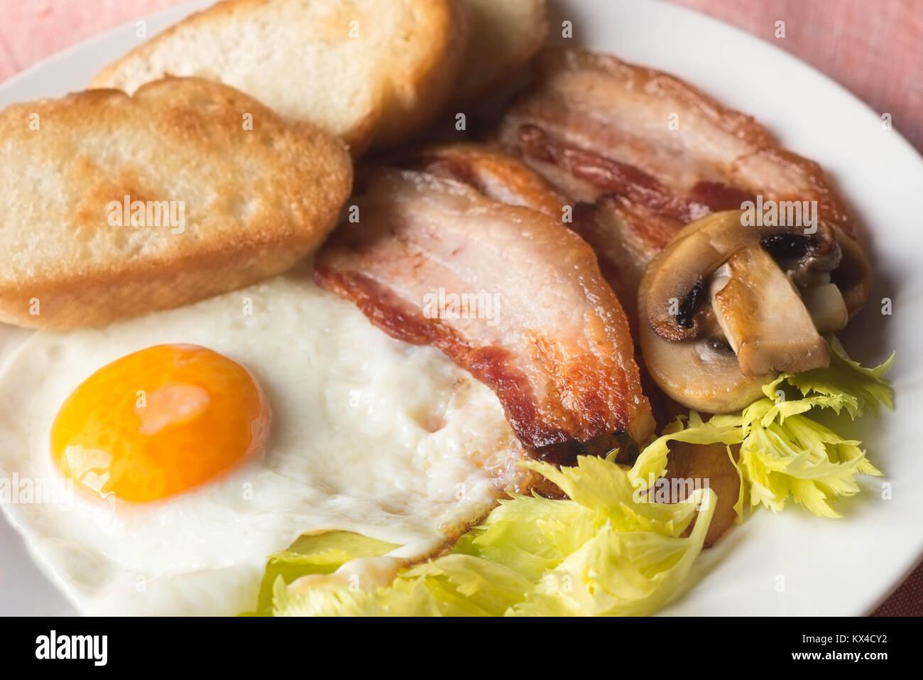 Spiegelei, Speck, Toast und Pilz für Frühstück auf Platte Stockfoto