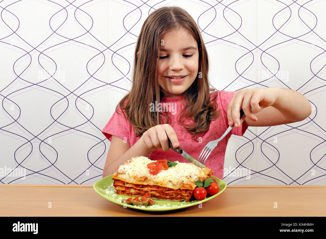 Hungrige kleine Mädchen essen lecker Lasagne Stockfoto