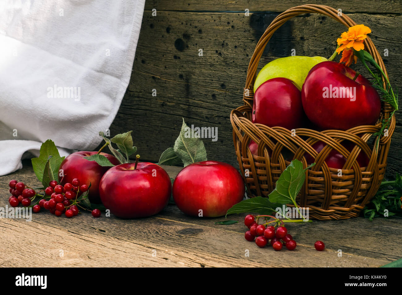 Äpfel und Birnen in einen Korb auf einem hölzernen Hintergrund Stockfoto