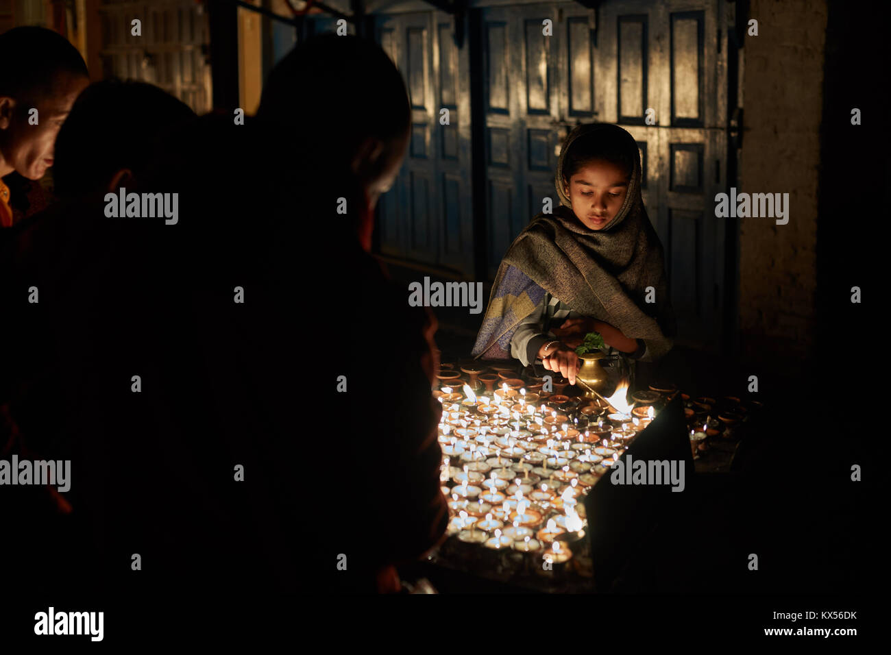 Nepali girl Beleuchtung buddhistische Kerzen, Boudhanath, Kathmandu, Nepal Stockfoto