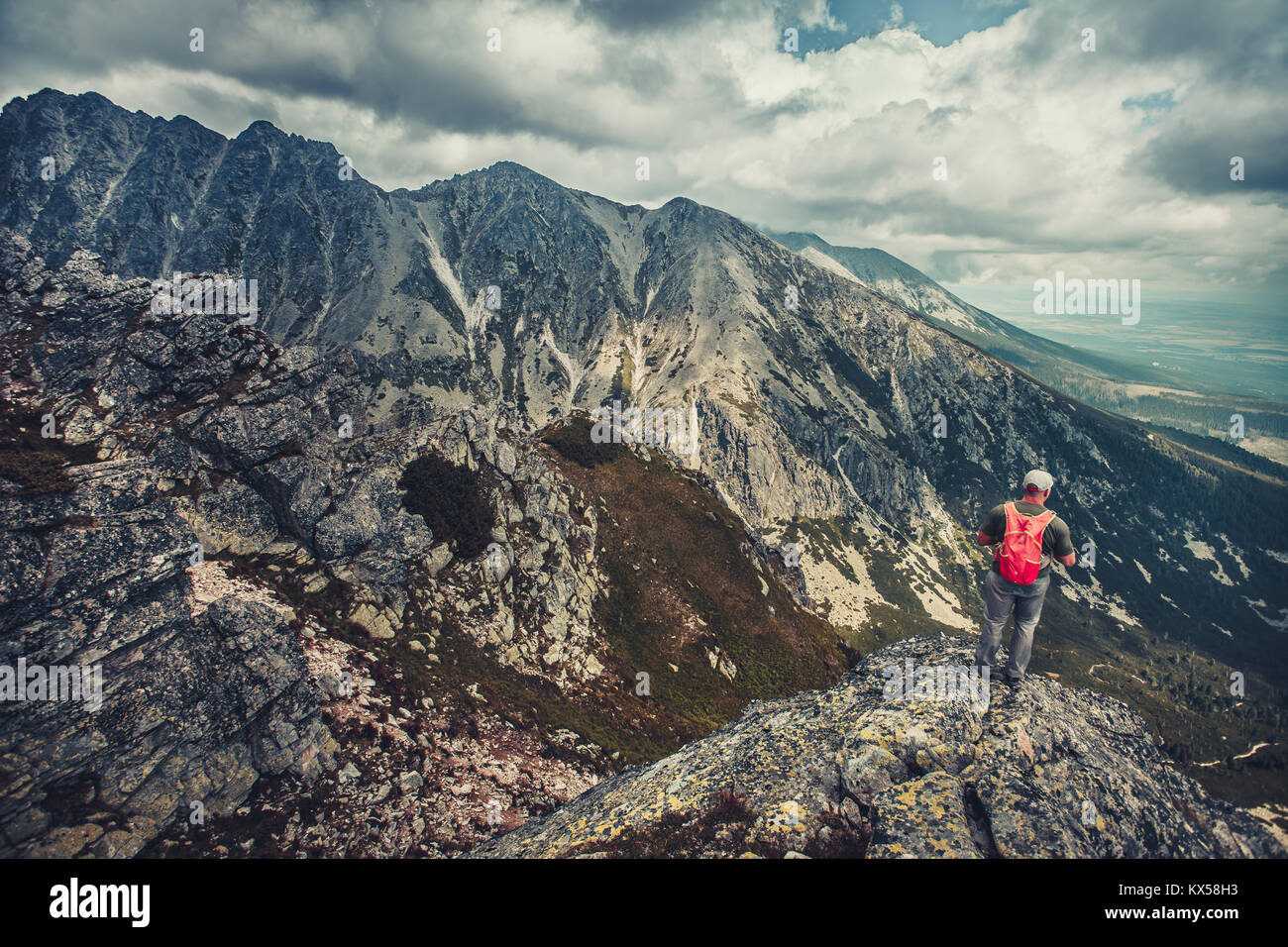 Ein Wanderer steht am Rande des Abgrunds in den Bergen der Hohen Tatra, Slowakei. Outdoor extreme Aktivität. Unvergesslichen herrlichen Panoramablick. Stockfoto