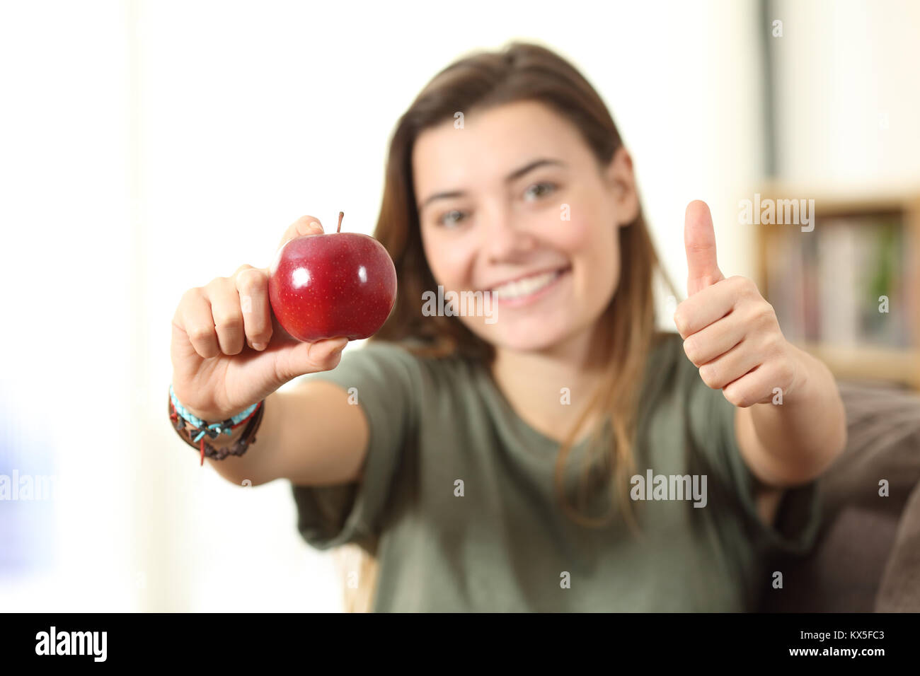 Vorderansicht Porträt eines gesunden jugendlich zeigen einen Apple mit Daumen hoch zu Hause Stockfoto