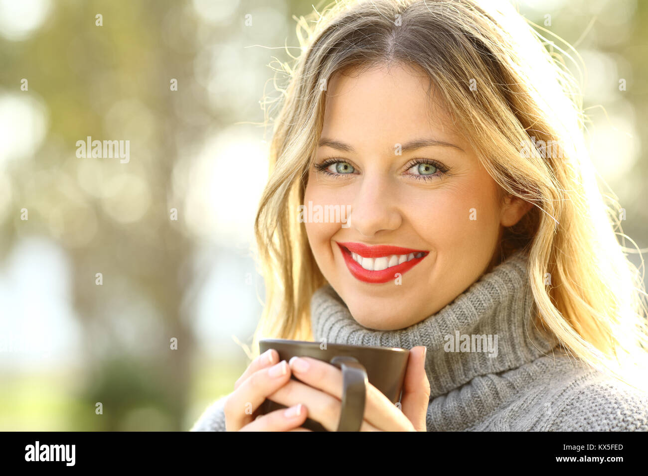 Porträt einer Frau gerne eine Tasse Kaffee und suchen Sie in einem Park im Winter Stockfoto