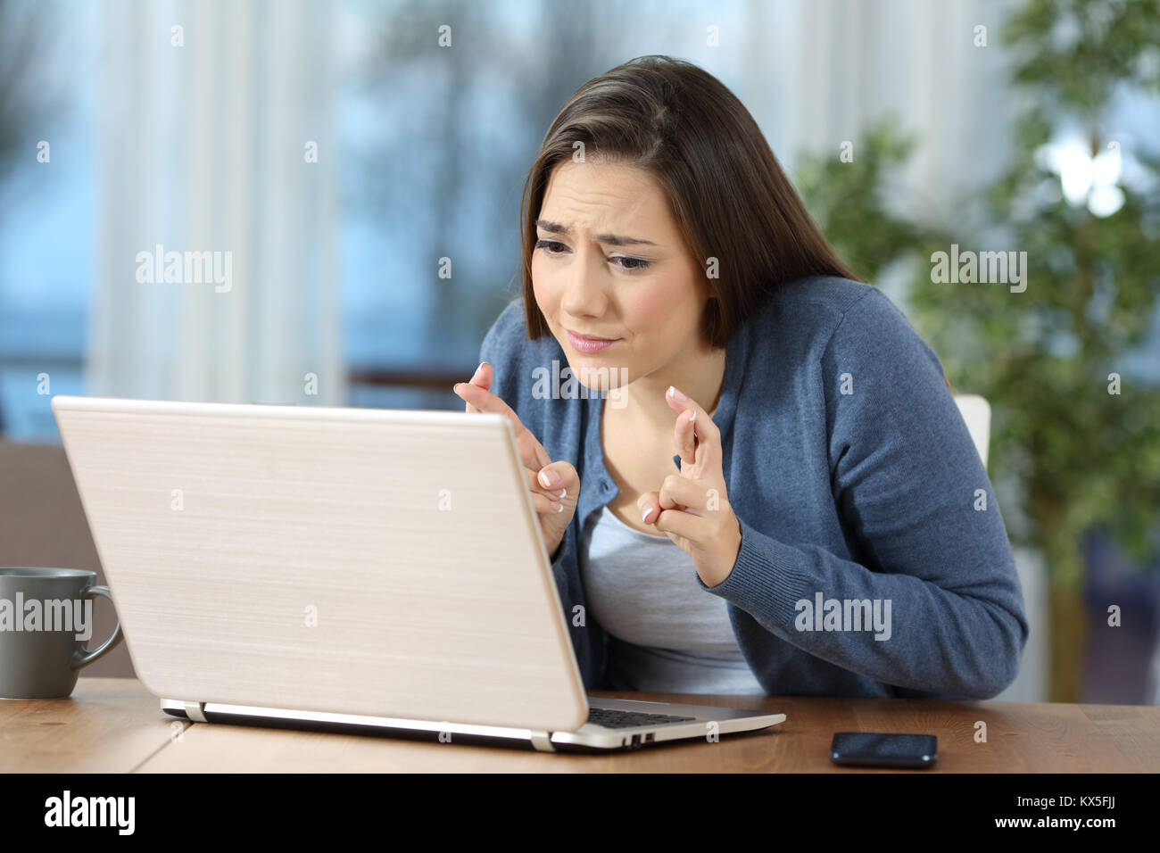 Besorgt, Frau die Daumen auf die Überprüfung der Inhalte in einem Laptop zu Hause Stockfoto