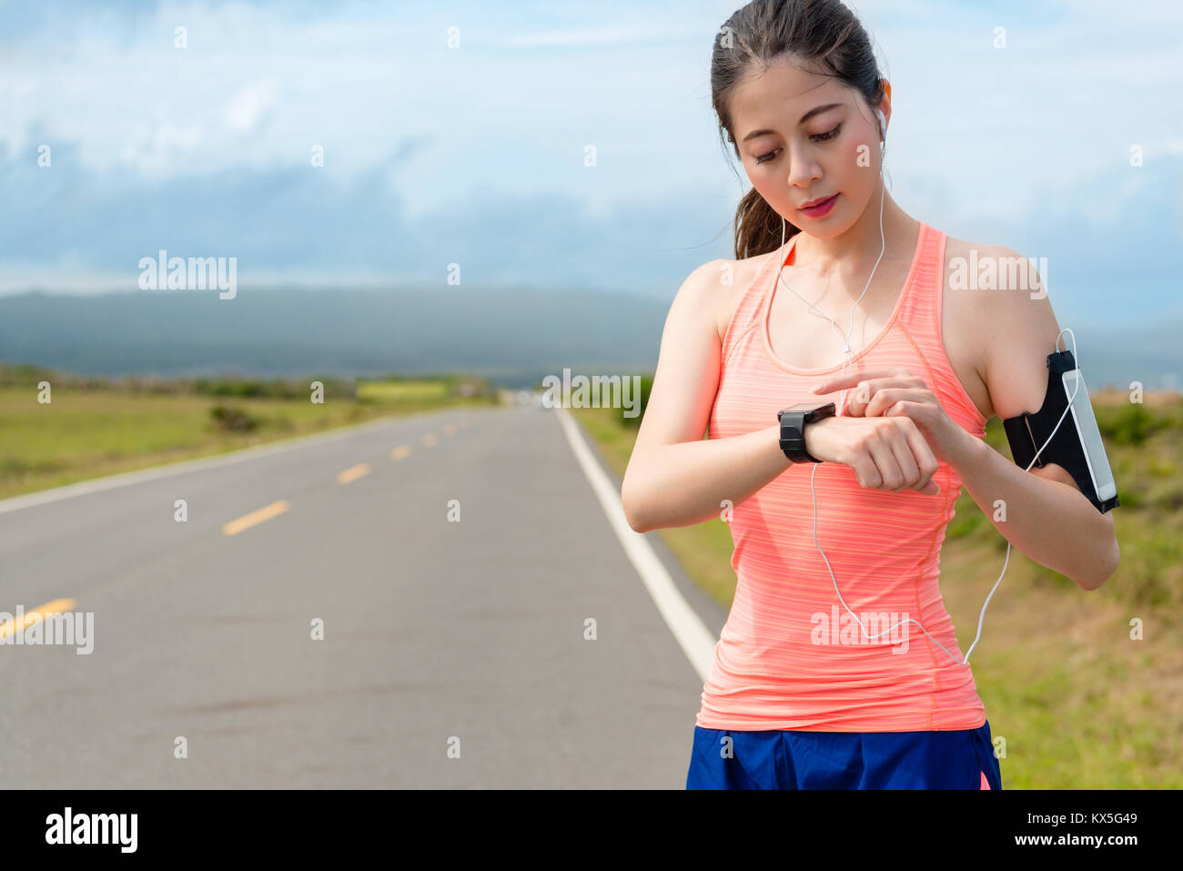 Professionelle junge Sportlerin Planung, die auf der Straße mit smartwatch Datensatz persönliche Herzfrequenz und Kontrolle online GPS-route Workout zu trainieren. Stockfoto