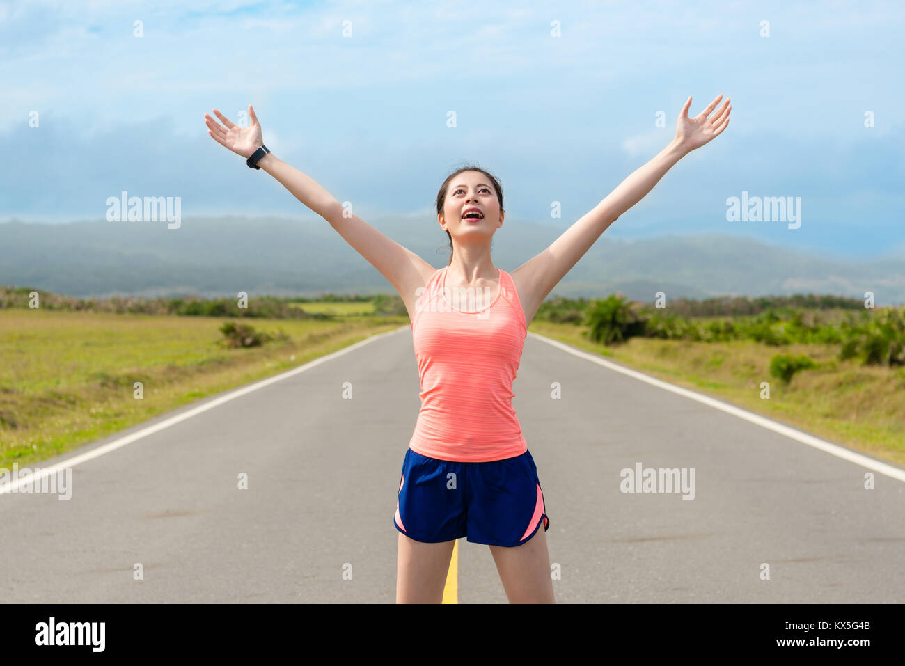 Schöne fröhliche Frau Jogger auf der Straße und zur Eröffnung der Arme zu genießen Landschaft, als sie vorbereitet Lauftraining. Stockfoto