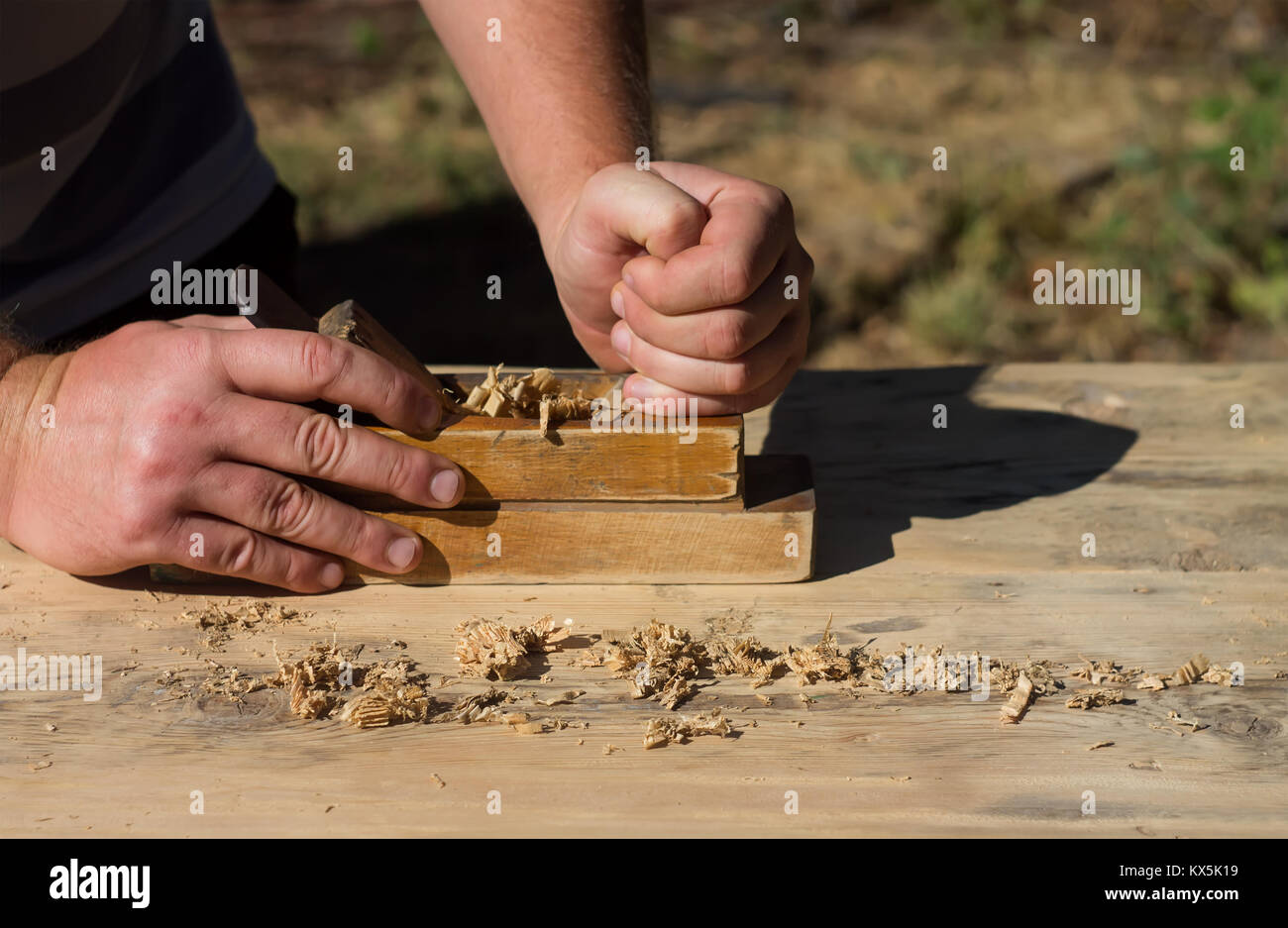 Die Hände eines Zimmermanns gehobeltes Holz Flugzeuge, die Arbeit an der Natur Stockfoto