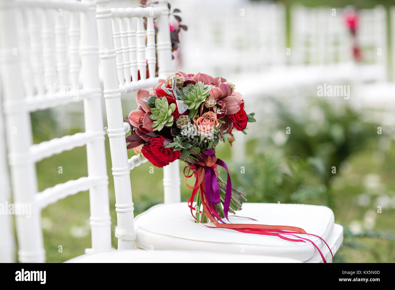 Atemberaubenden roten Brautstrauß auf weißem Stuhl. Trauung. Mix von  Sukkulenten, Orchideen und Rosen Stockfotografie - Alamy