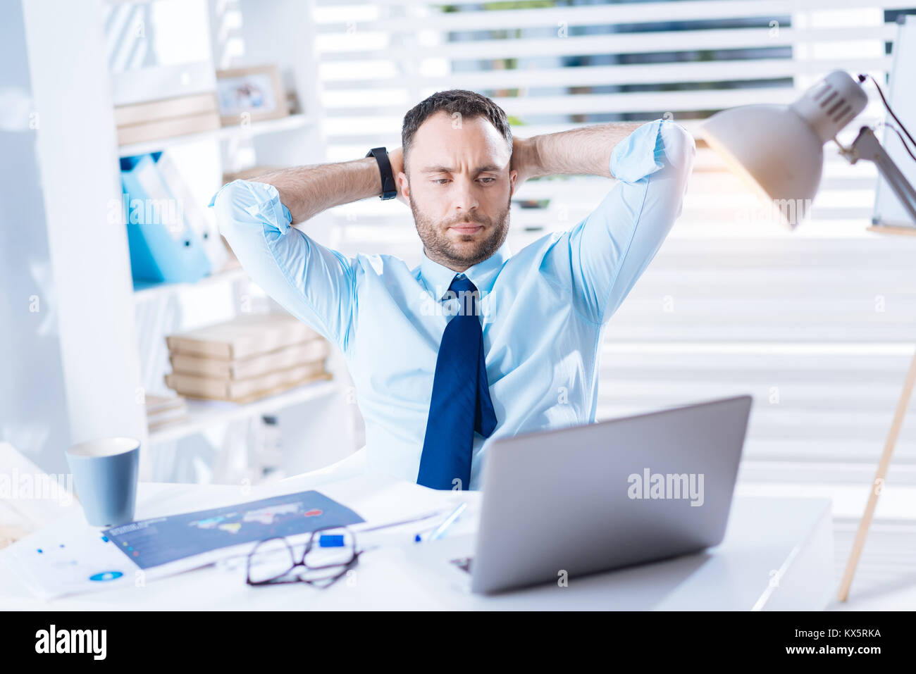 Nachdenklichen jungen Mann am Bildschirm eines Laptop bei Arbeiten Stockfoto