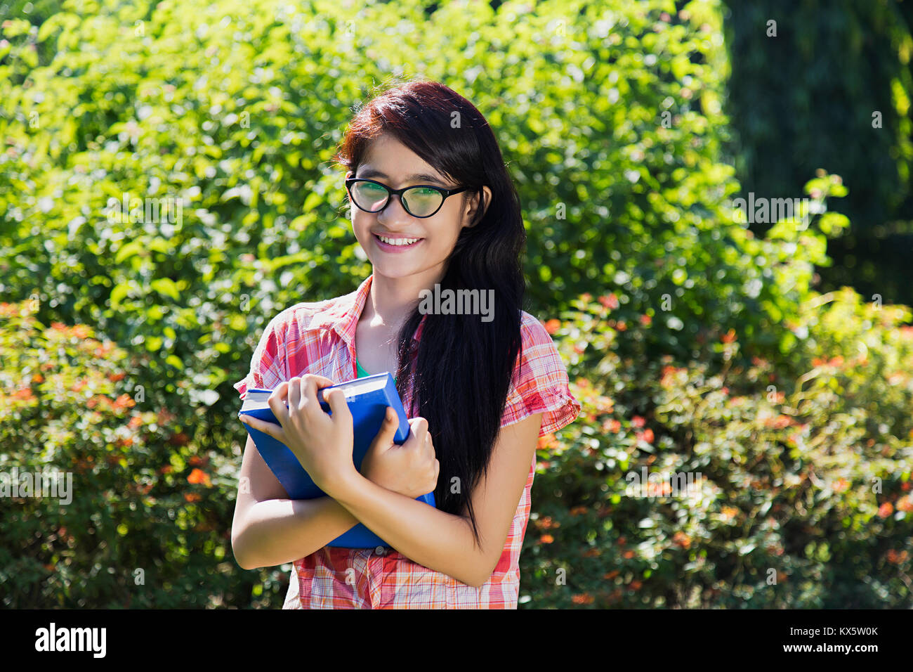 1 indischen College Girl Holding Buch zeigt Thumbsup in Park Stockfoto