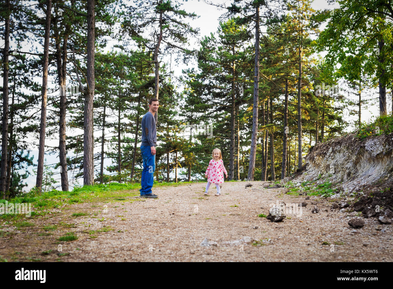 Glückliche junge einzelner Vater bei einem Spaziergang im Park mit seinem Kleinkind Tochter. Familie Lachen und Spaß im Freien. Stockfoto