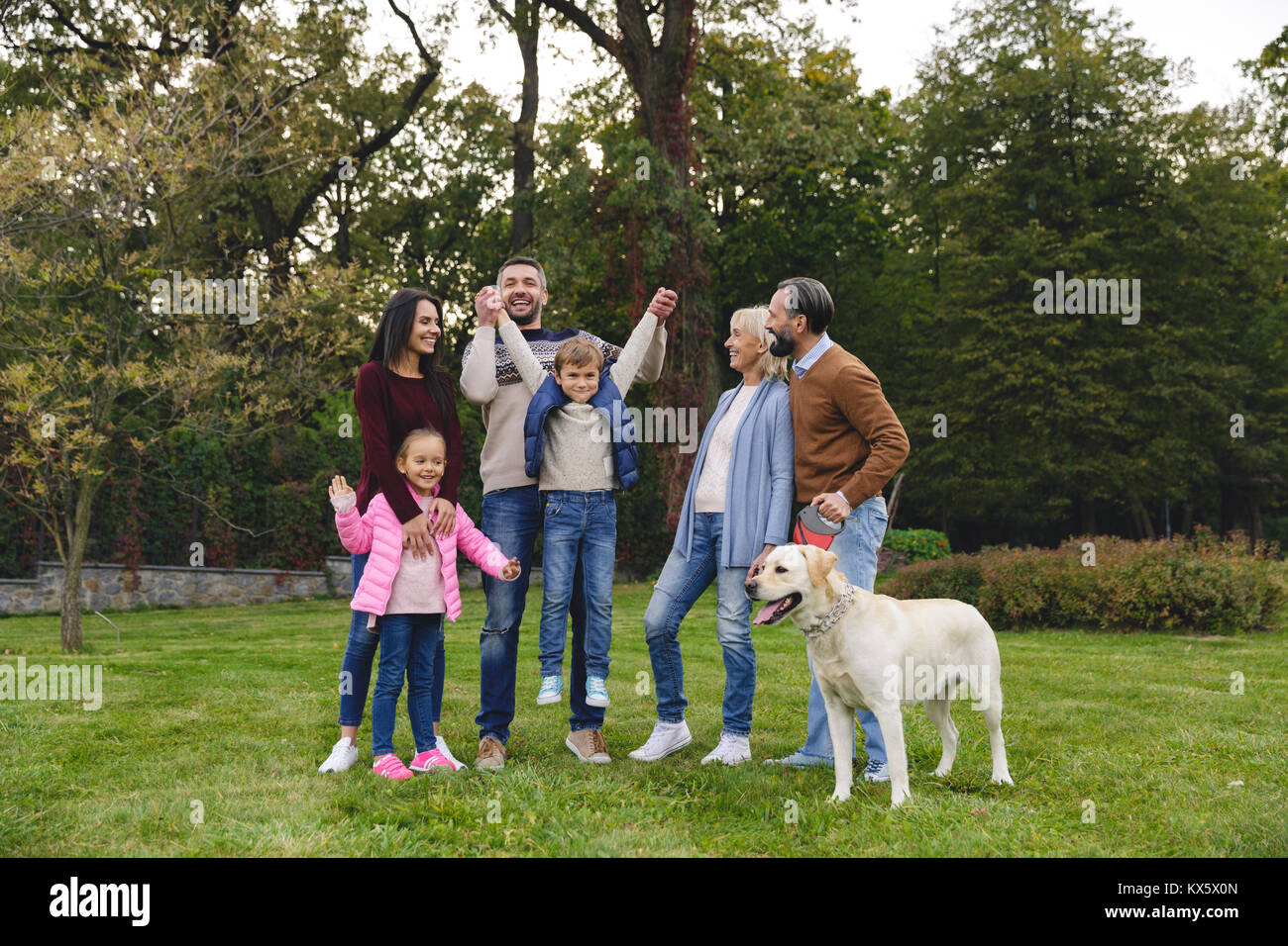 Gerne große Familie mit Labrador Retriever Hund spielen im Park Stockfoto