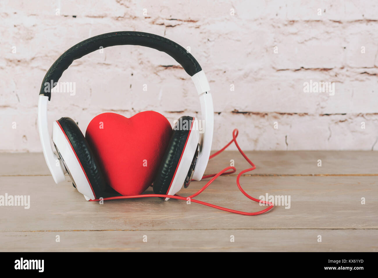Valentinstag, Herzen mit Kopfhörern auf einem Holztisch Stockfoto