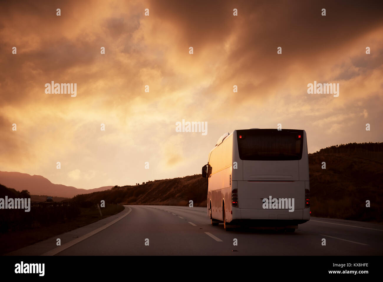 Weißen Bus fahren auf der Straße mit Blick auf den Sonnenuntergang Stockfoto