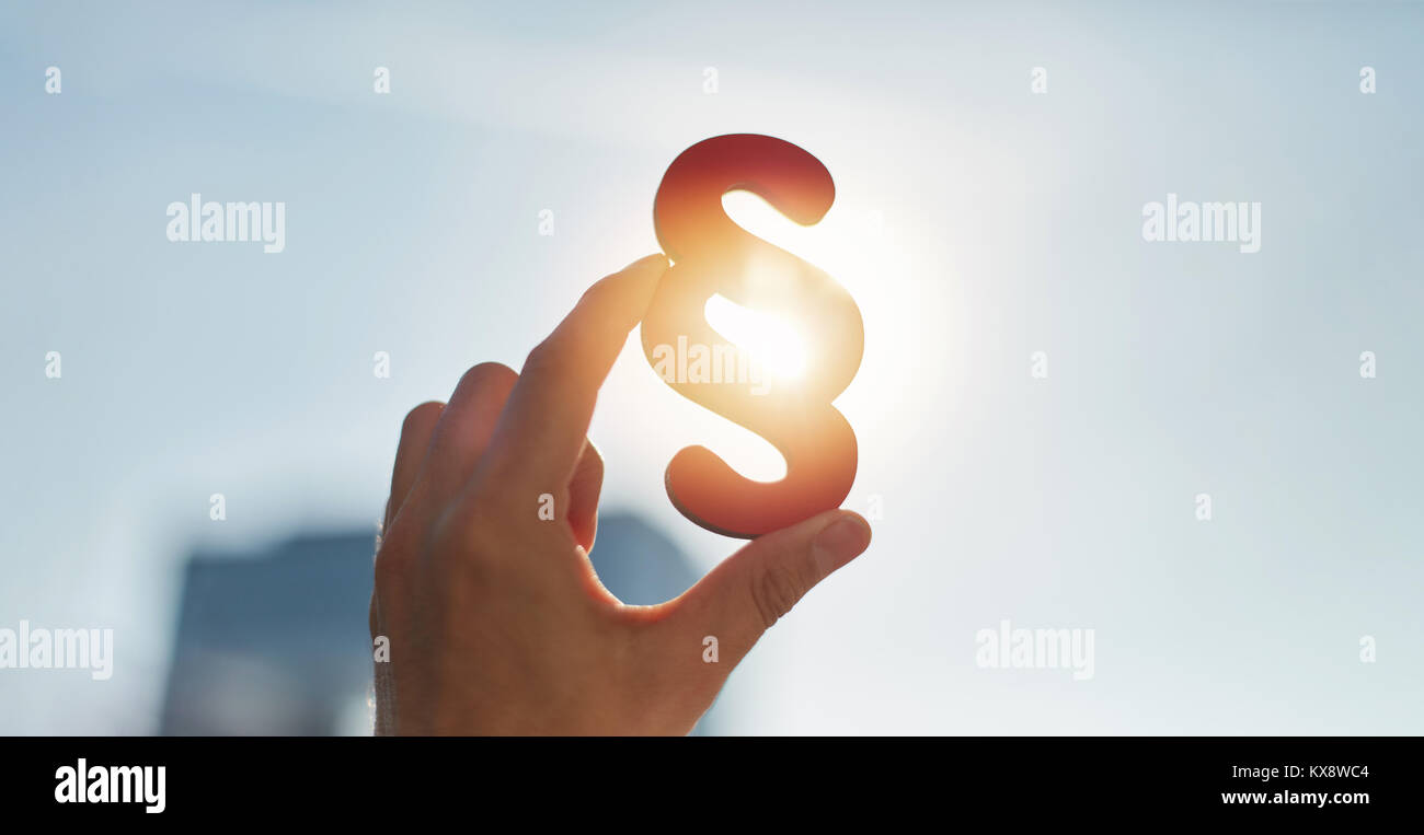 Hand hält Absatz Symbol in der Sonne am Himmel Stockfoto