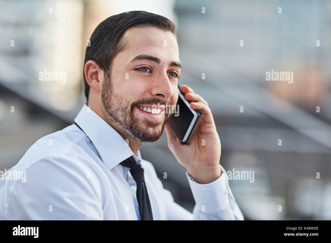 Young Business Mann glücklich über die Nachricht auf dem Smartphone Anruf empfangen Stockfoto