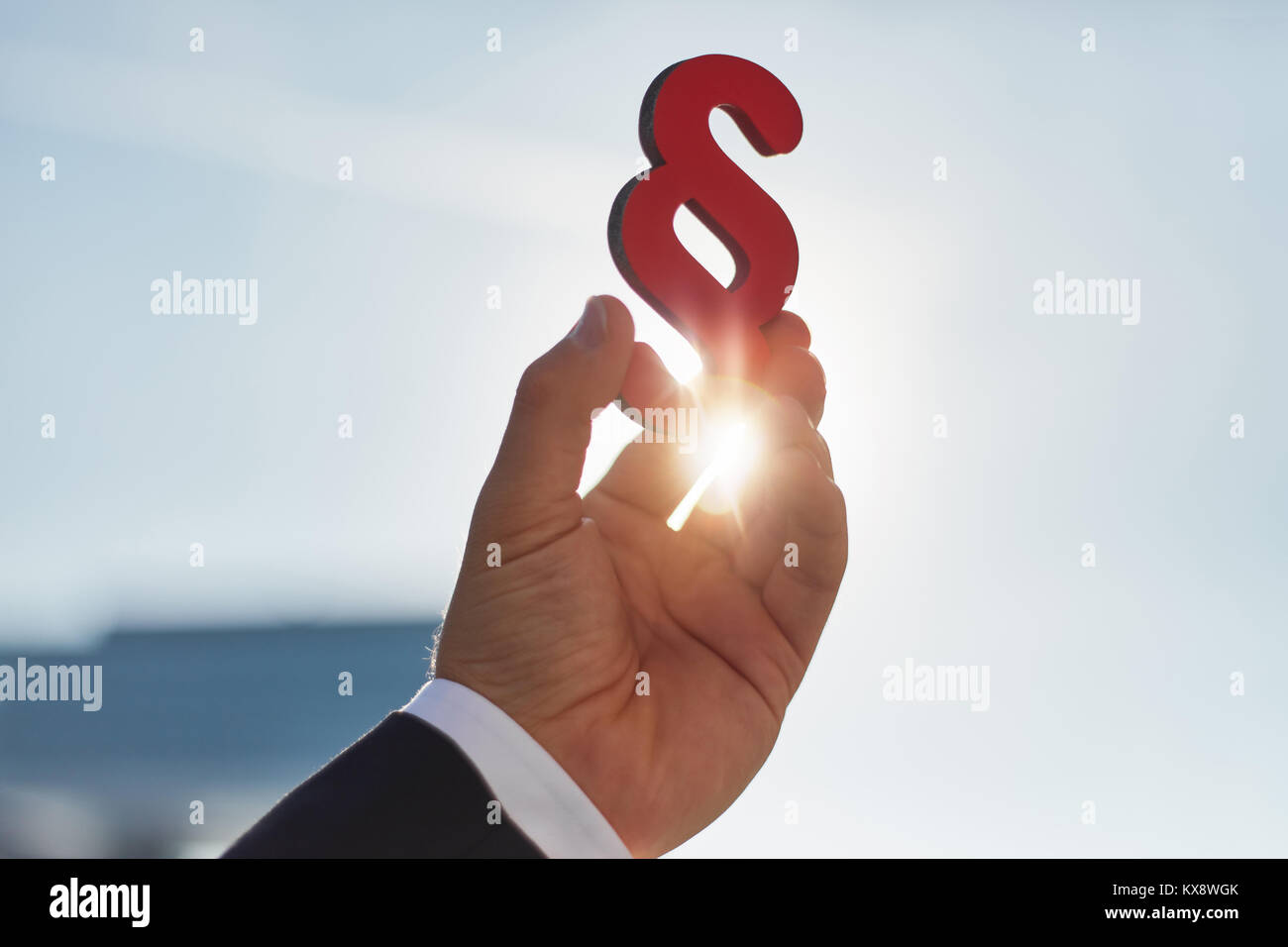 Hand hält Absatz Zeichen in der Sonne als Symbol für die Idee des Gesetzes Stockfoto