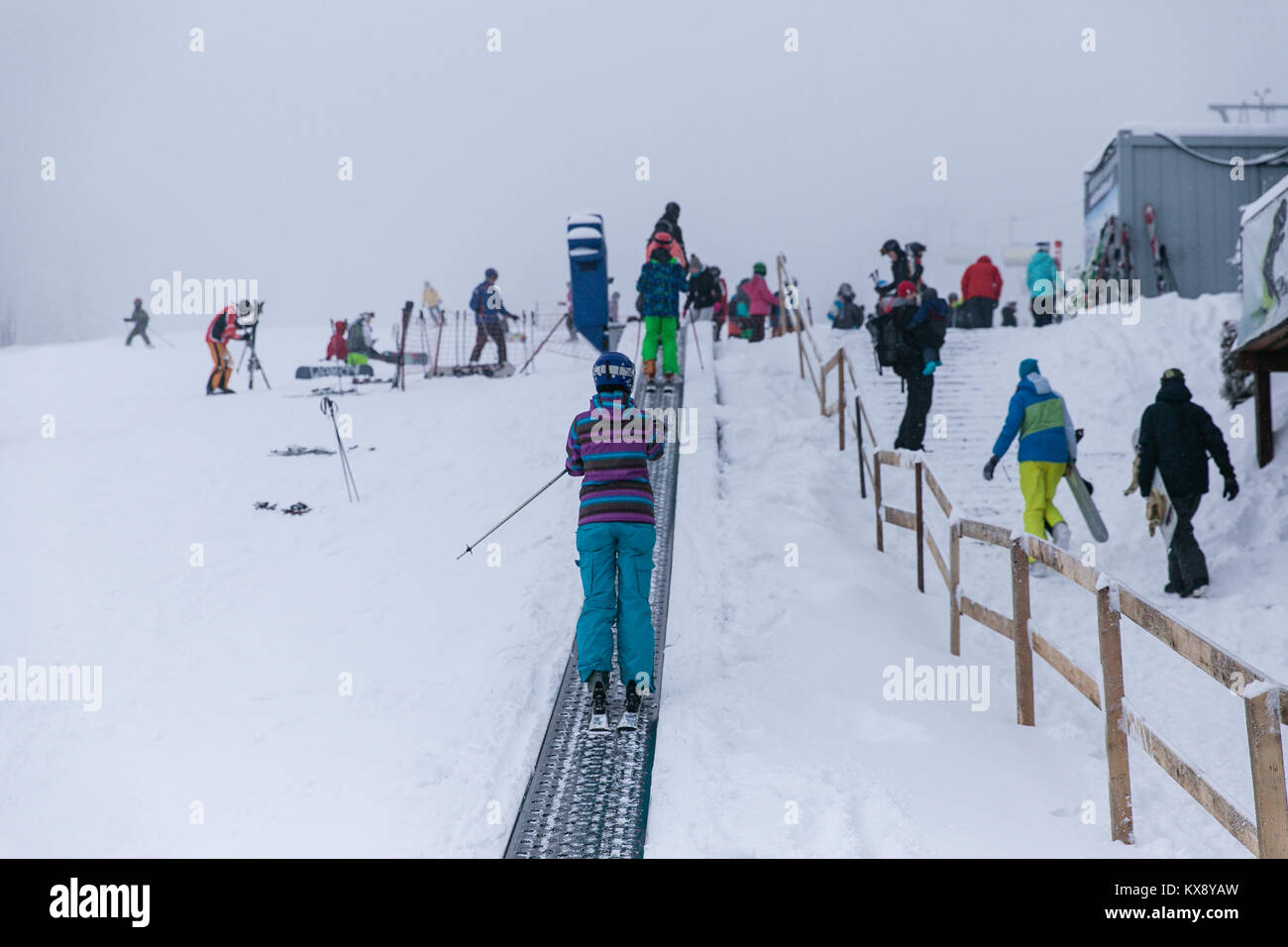 Skifahrer auf einem Band Skilift auf dem Weg in die zweite Etappe der Sessellift bringt Touristen auf den Gipfel des Berges in Szczyrk Skrzyczne, Polen Stockfoto