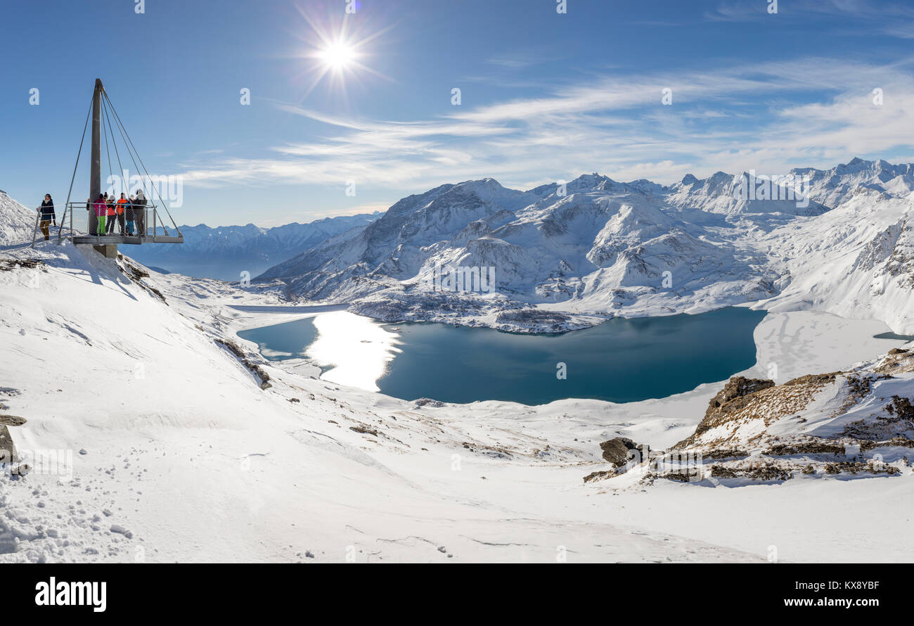 VAL CENIS, Frankreich - 31. Dezember 2017: Menschen mit Blick auf Mont Cenis See und die umliegenden Berge von der Plattform auf der Col de la Met, Stockfoto
