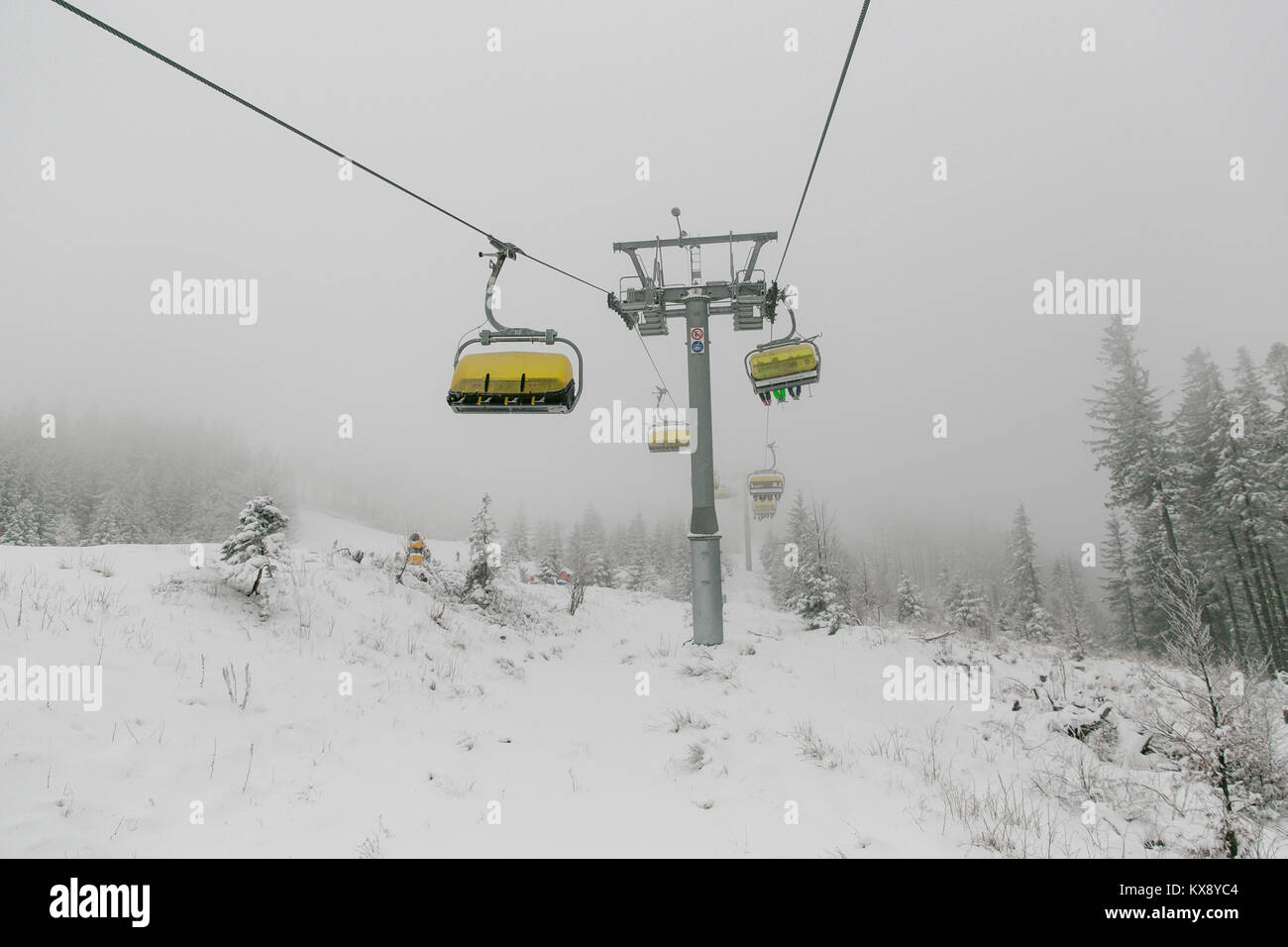 Ski Sessellift bringt Skifahrer und Snowboarder auf den Berg Skrzyczne nach starker Schneefall auf einem nebligen Wintertag in Szczyrk ski resort in Polen Stockfoto