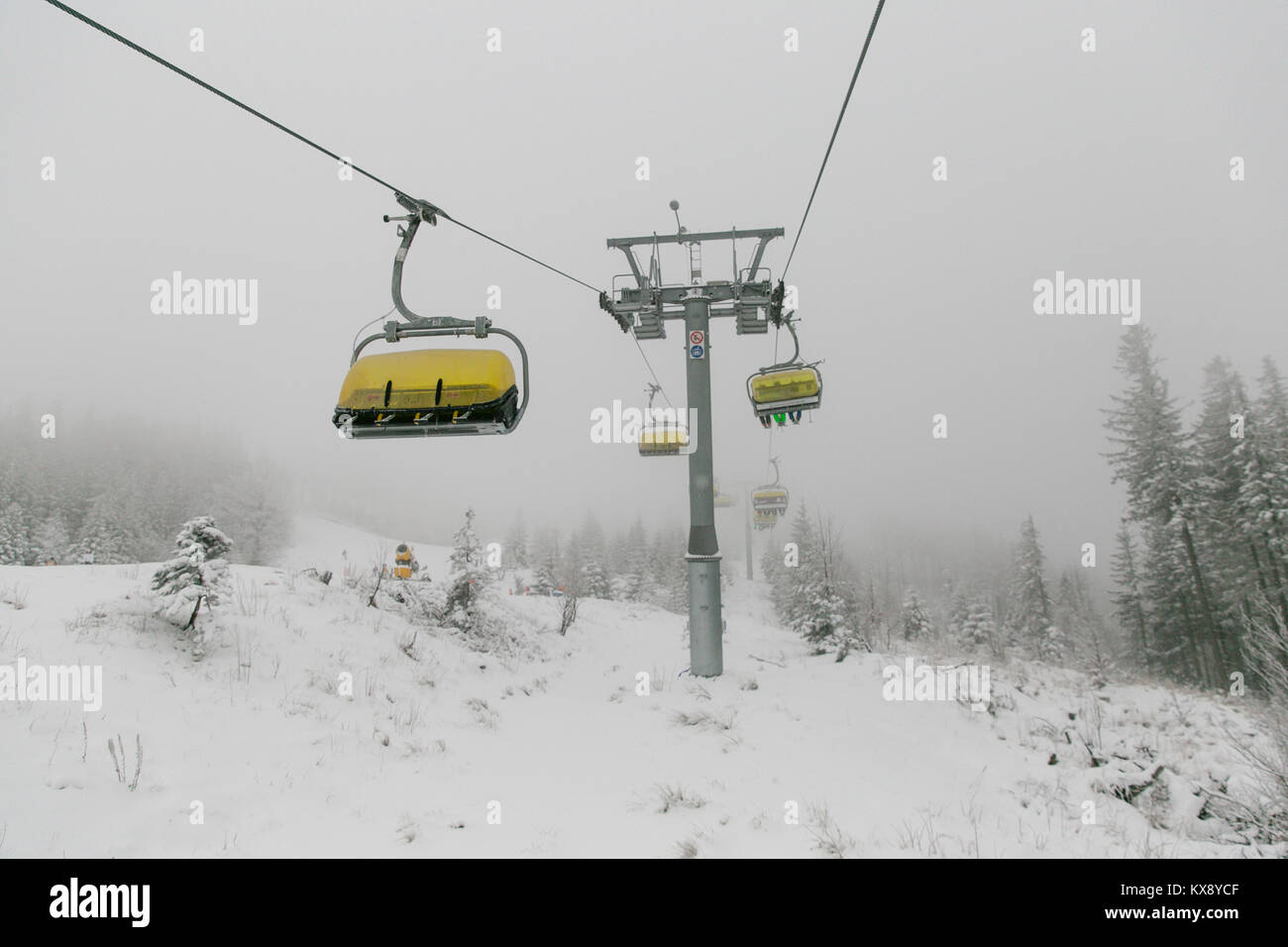 Ski Sessellift bringt Skifahrer und Snowboarder auf den Berg Skrzyczne nach starker Schneefall auf einem nebligen Wintertag in Szczyrk ski resort in Polen Stockfoto