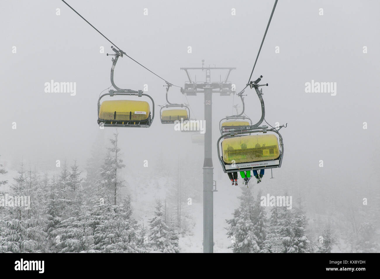 Ski Sessellift bringt Skifahrer und Snowboarder auf den Berg Skrzyczne nach starker Schneefall auf einem nebligen Wintertag in Szczyrk ski resort in Polen Stockfoto
