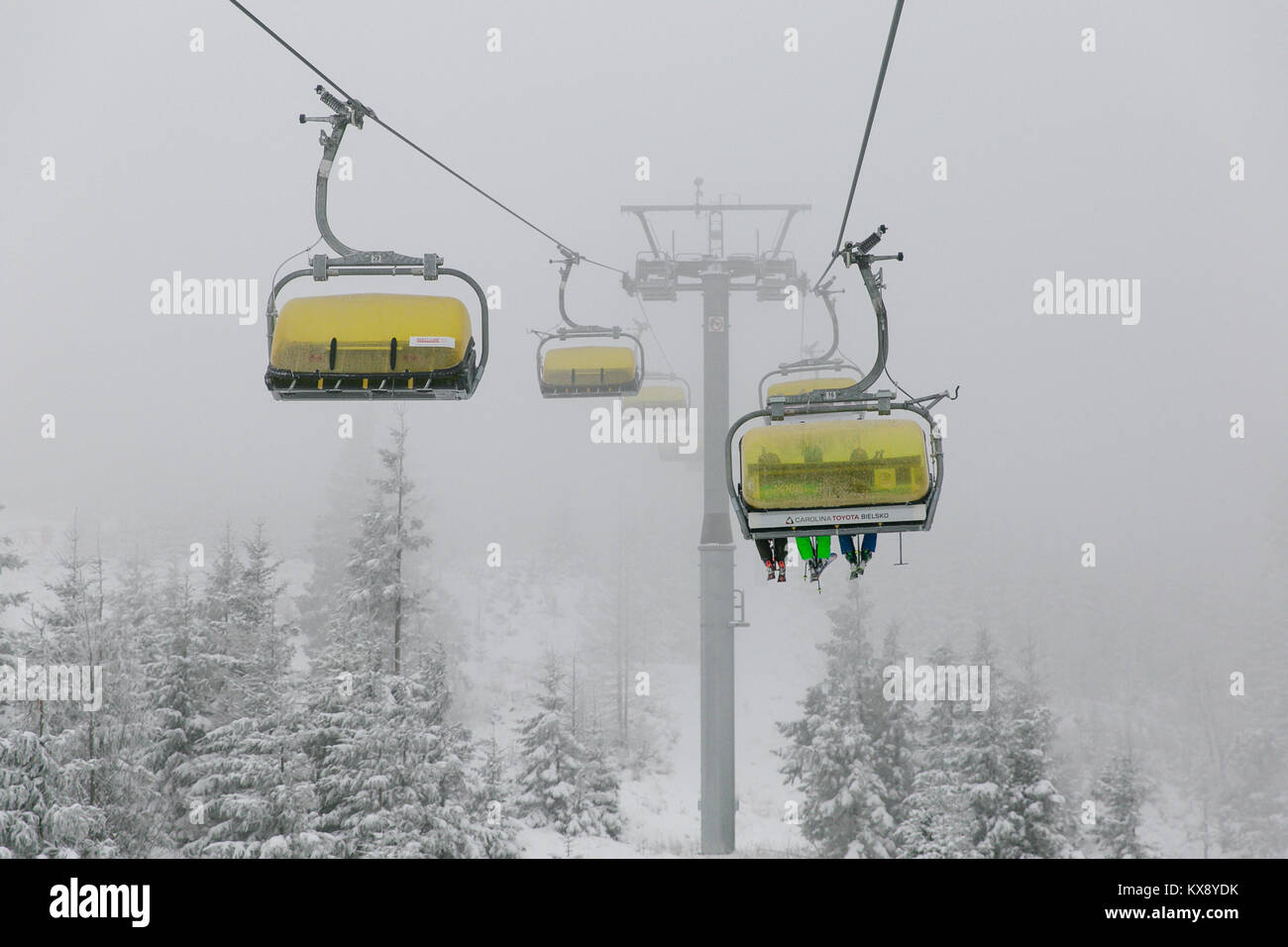 Ski Sessellift bringt Skifahrer und Snowboarder auf den Berg Skrzyczne nach starker Schneefall auf einem nebligen Wintertag in Szczyrk ski resort in Polen Stockfoto