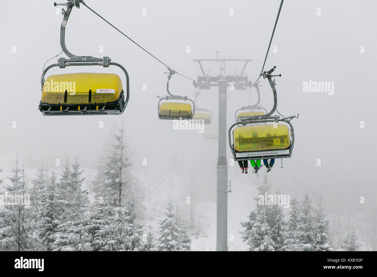 Ski Sessellift bringt Skifahrer und Snowboarder auf den Berg Skrzyczne nach starker Schneefall auf einem nebligen Wintertag in Szczyrk ski resort in Polen Stockfoto