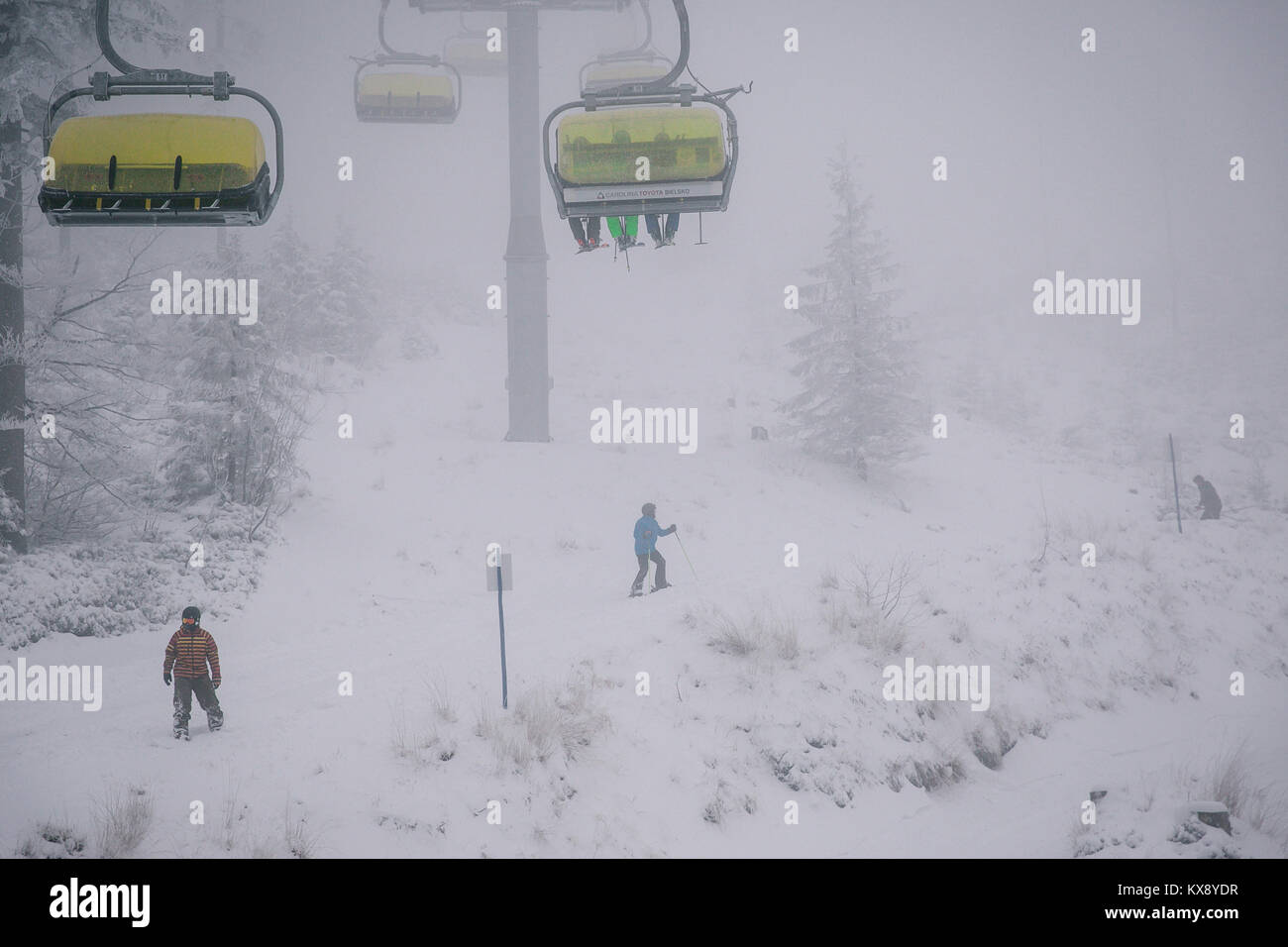 Ski Sessellift bringt Skifahrer und Snowboarder auf den Berg Skrzyczne nach starker Schneefall auf einem nebligen Wintertag in Szczyrk ski resort in Polen Stockfoto