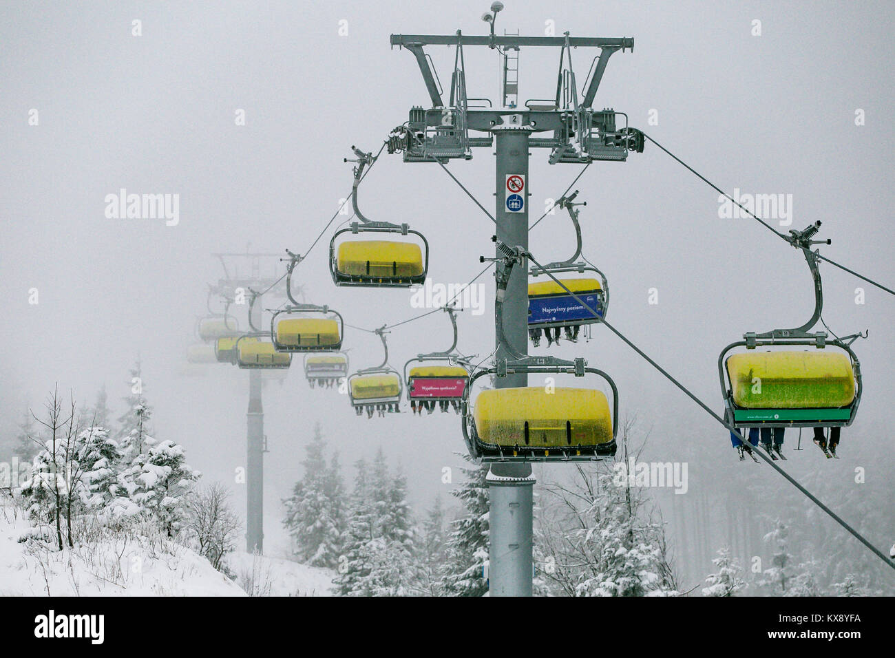 Ski Sessellift bringt Skifahrer und Snowboarder auf den Berg Skrzyczne nach starker Schneefall auf einem nebligen Wintertag in Szczyrk ski resort in Polen Stockfoto