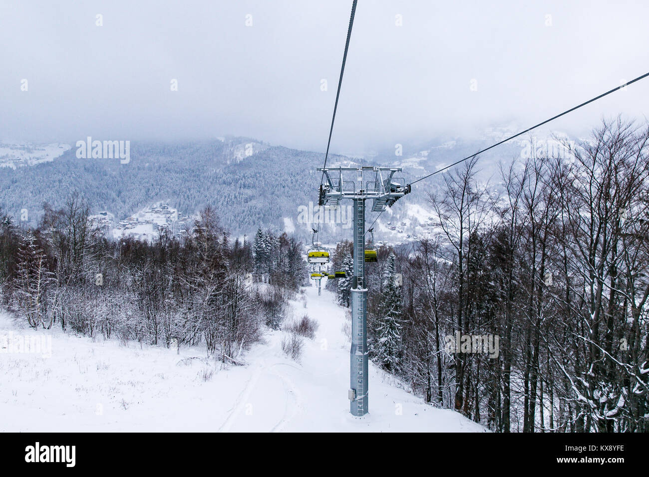 Ski Sessellift bringt Skifahrer und Snowboarder auf den Berg Skrzyczne nach starker Schneefall auf einem nebligen Wintertag in Szczyrk ski resort in Polen Stockfoto