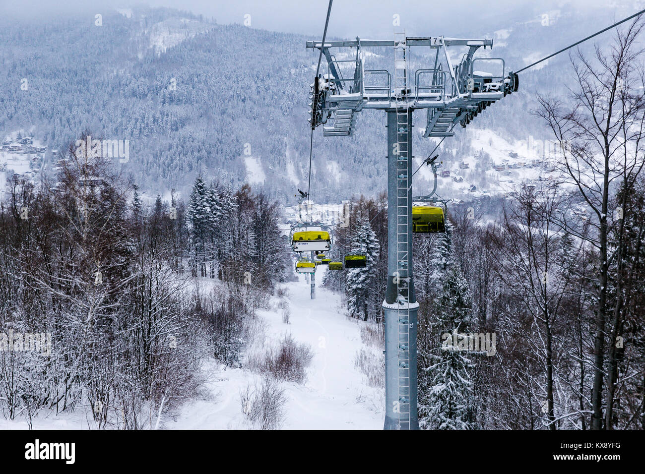 Ski Sessellift bringt Skifahrer und Snowboarder auf den Berg Skrzyczne nach starker Schneefall auf einem nebligen Wintertag in Szczyrk ski resort in Polen Stockfoto