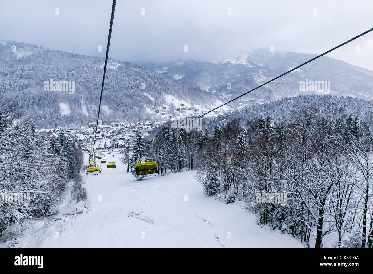 Ski Sessellift bringt Skifahrer und Snowboarder auf den Berg Skrzyczne nach starker Schneefall auf einem nebligen Wintertag in Szczyrk ski resort in Polen Stockfoto