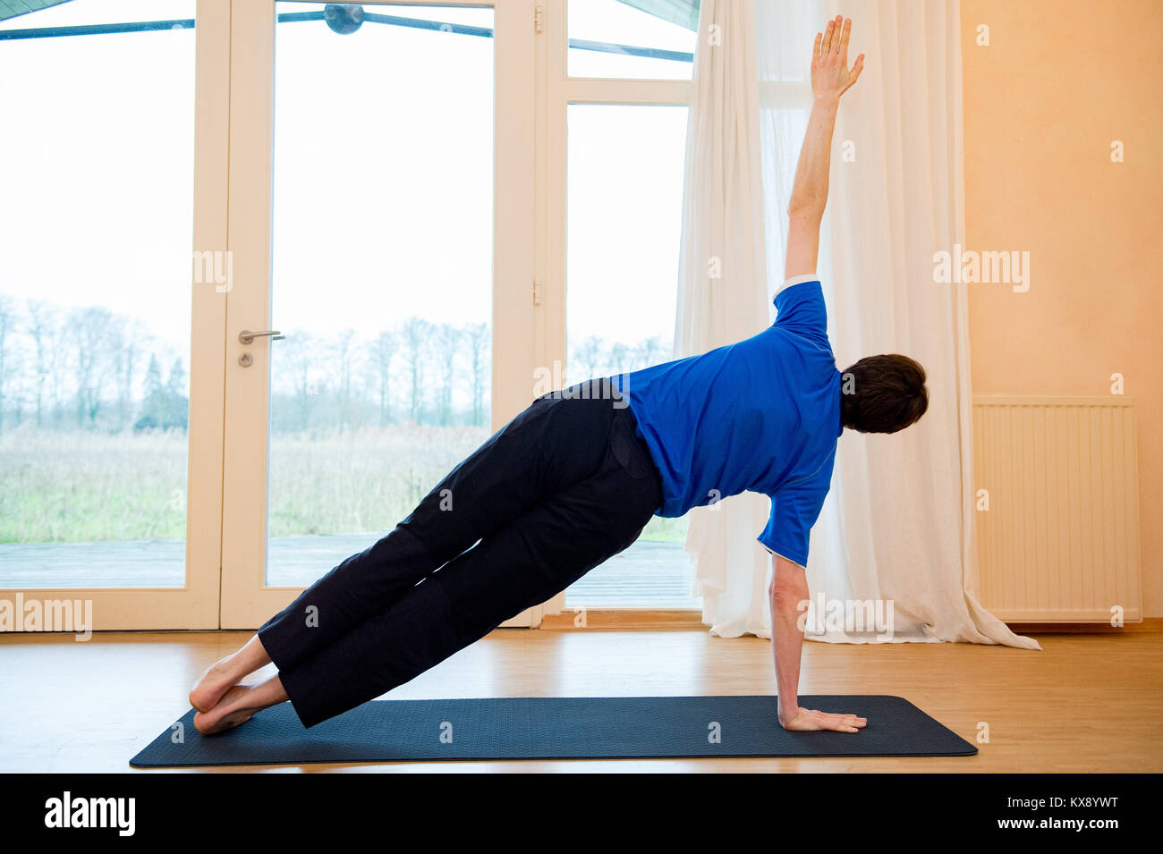 Man Yoga im Innenraum in einem Retreat Raum tun Seite Liegestütz-Vasisthasana Stockfoto