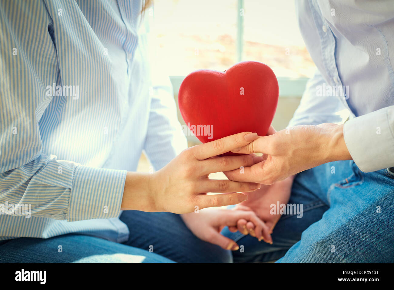 Herz in den Händen eines jungen Paares. Stockfoto