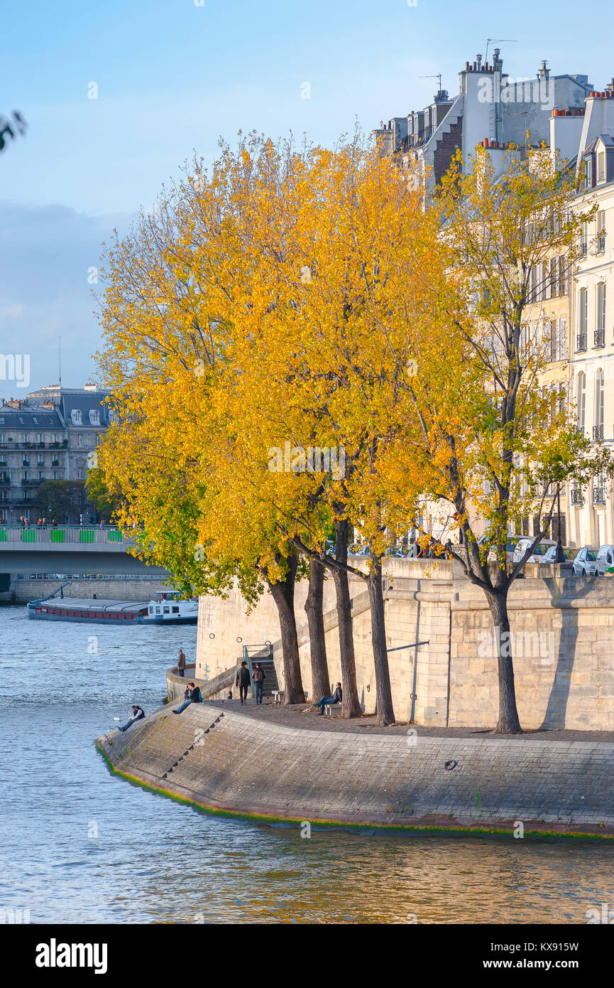 Paris im Herbst Herbst auf einem herbstlichen Nachmittag Menschen entspannen auf einem Damm entlang der Quai d ' Orléans im Zentrum von Paris. Stockfoto