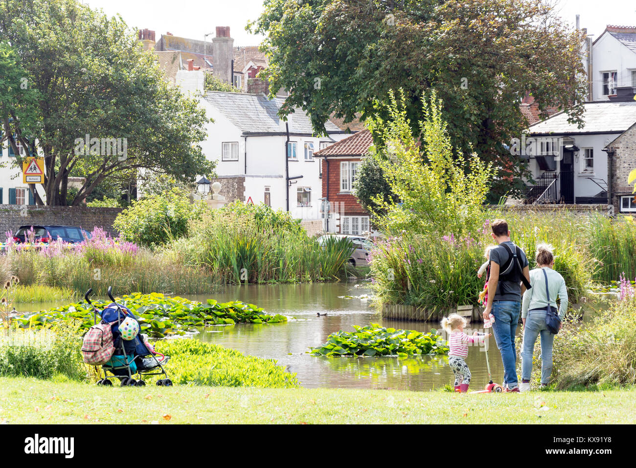 Familie mit Teich auf dem Grün, Rottingdean, East Sussex, England, Vereinigtes Königreich Stockfoto
