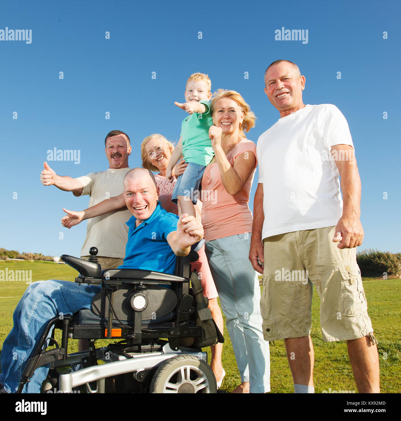 Behinderte Menschen mit einer Gruppe von Menschen außerhalb. Stockfoto