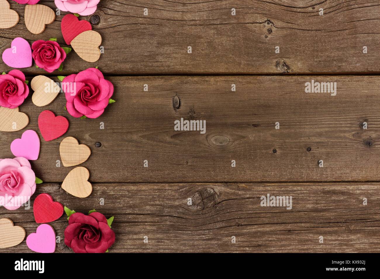 Valentines Tag Seite Grenze von Herzen aus Holz und Papier Rosen gegen eine rustikale Holz Hintergrund mit kopieren. Stockfoto