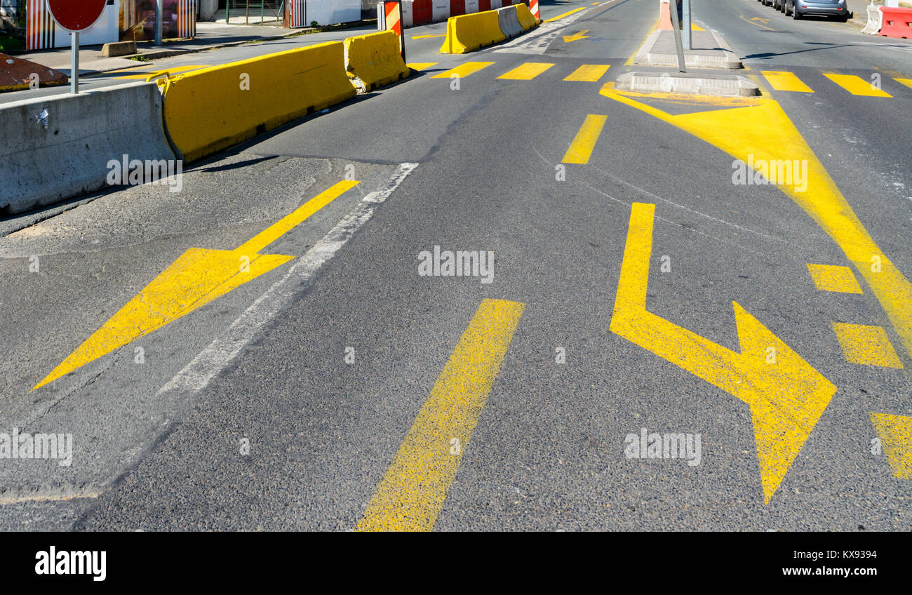 Gelbe temporäre Fahrbahnmarkierungen an einer Kreuzung in der Nähe einer Baustelle. Stockfoto