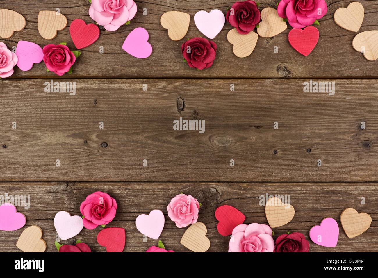Valentines Tag doppelten Umrandung von Herzen aus Holz und Papier Rosen gegen eine rustikale Holz Hintergrund mit kopieren. Stockfoto