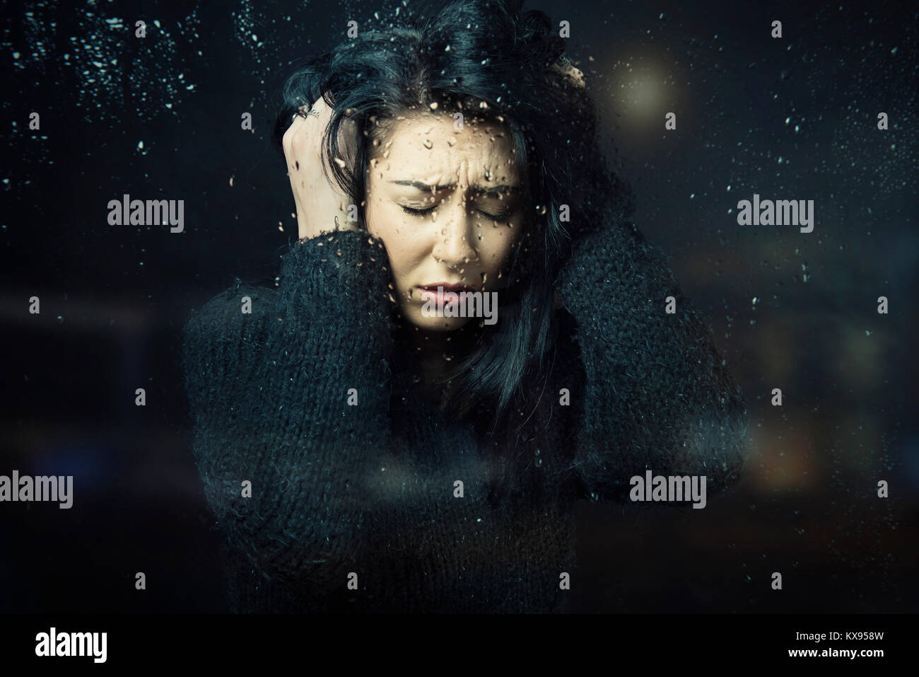 Distressed traurige Frau gedrückt, die Hände in Haar besorgt das Sitzen an regnerischen Fenster filmische Nahaufnahme portrait Stockfoto