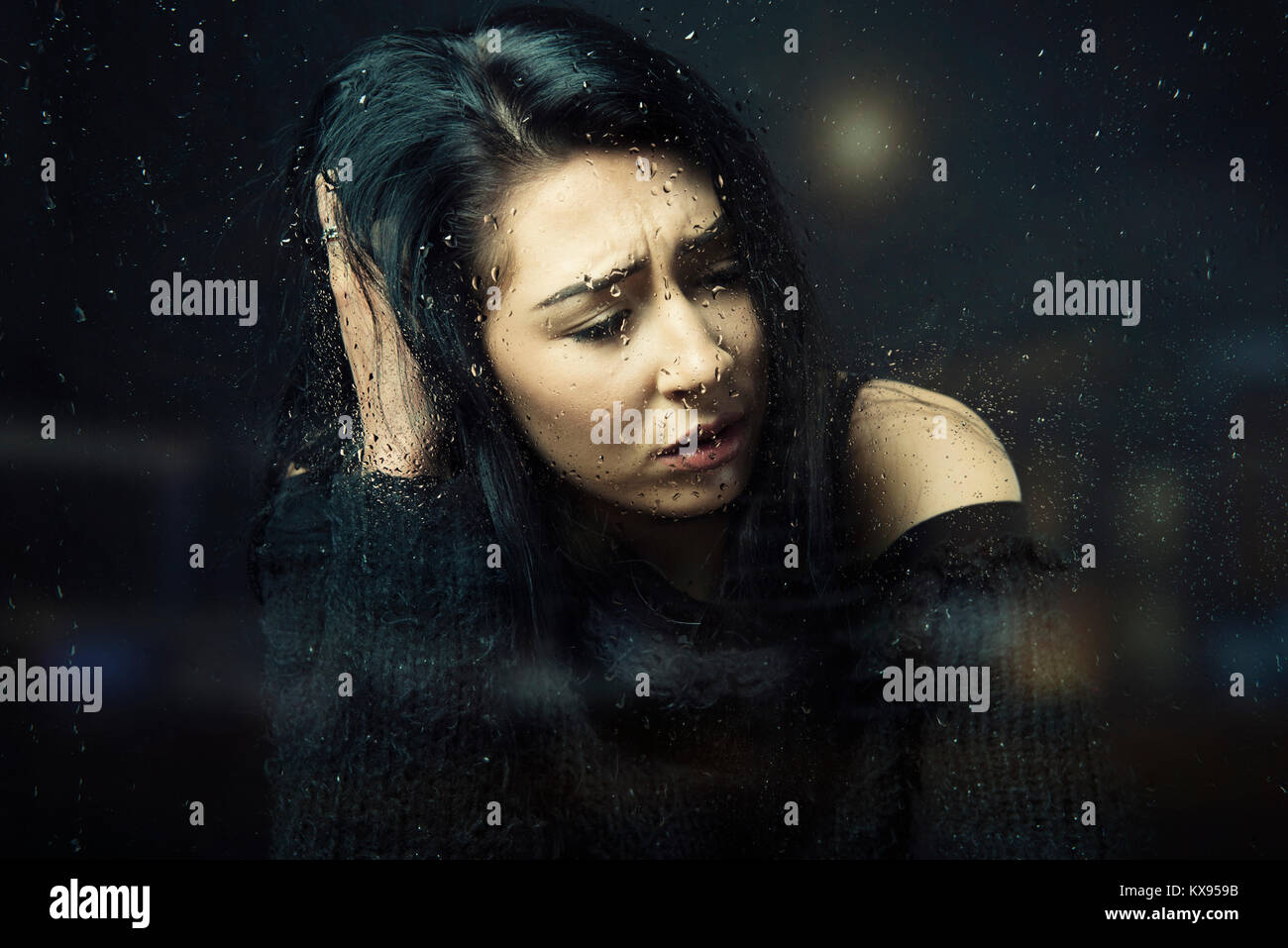 Unglücklich gedrückt traurige Teenager Frau weg, lehnte sich an Hand an regnerischen Fenster filmische Nahaufnahme Portrait sitzen Stockfoto