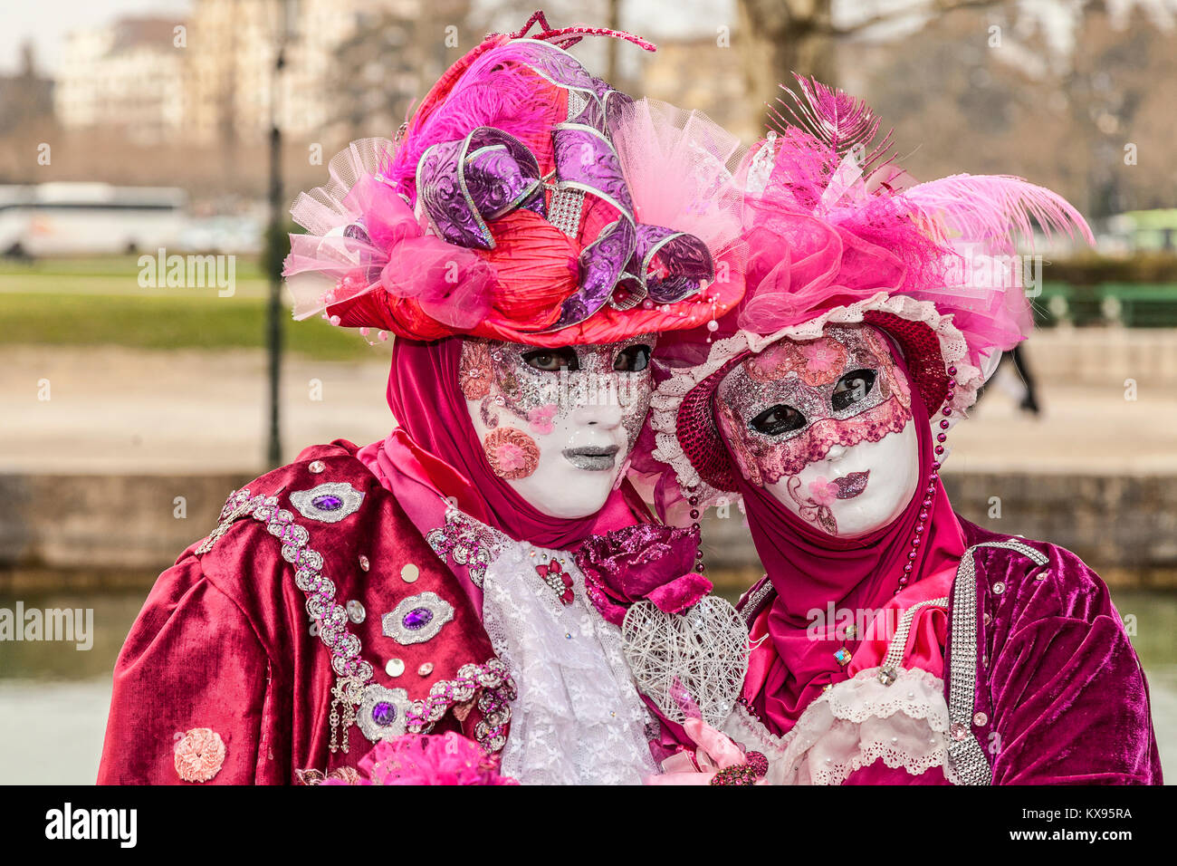 Annecy, France-March 15,2014: Umwelt Portrait von Paar in rot Kostüme in der Nähe von einem Kanal während der annecy Venezianischen Karneval verkleidet posiert. Jährlich Stockfoto